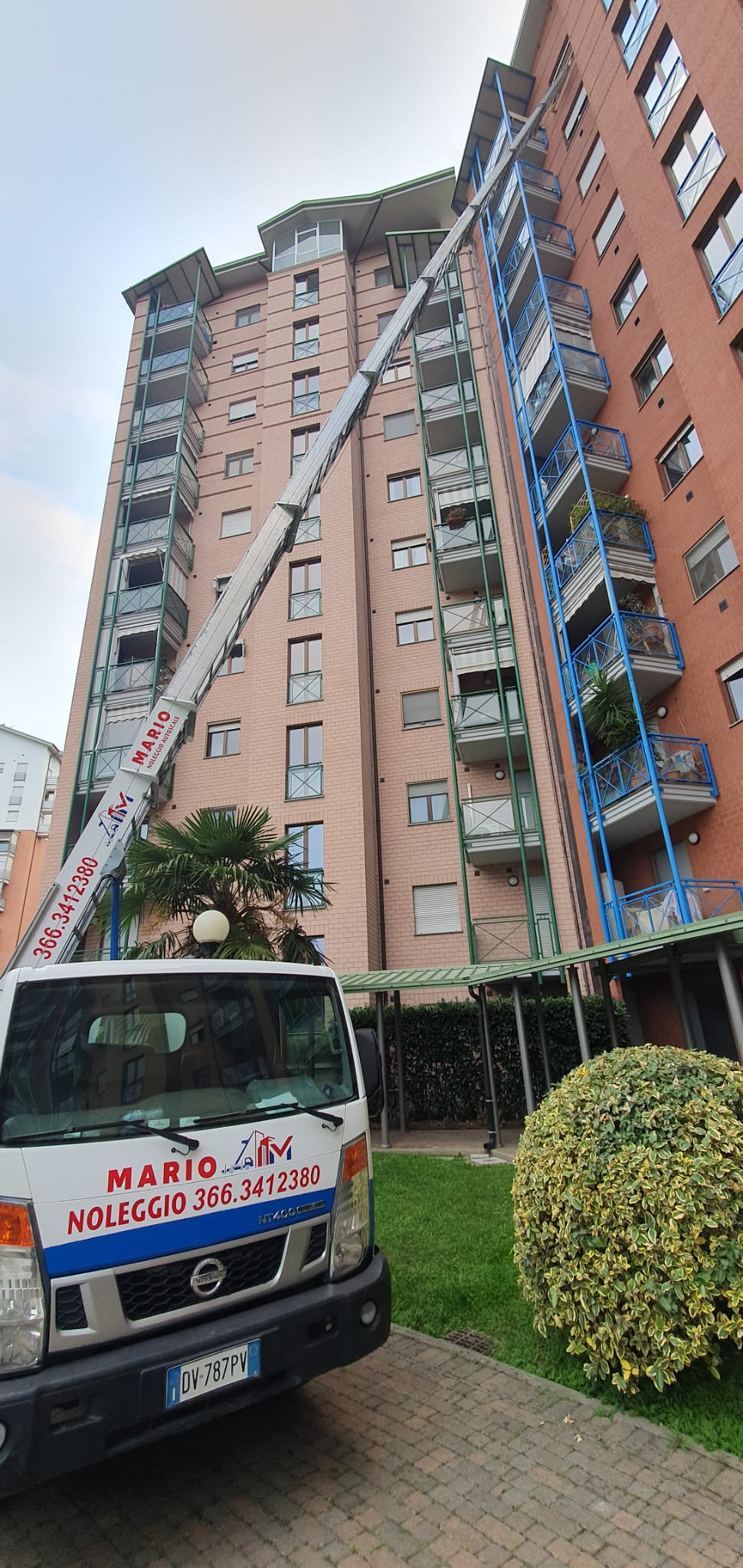 Autoscala con operatore che solleva materiale edile al decimo piano a Torino